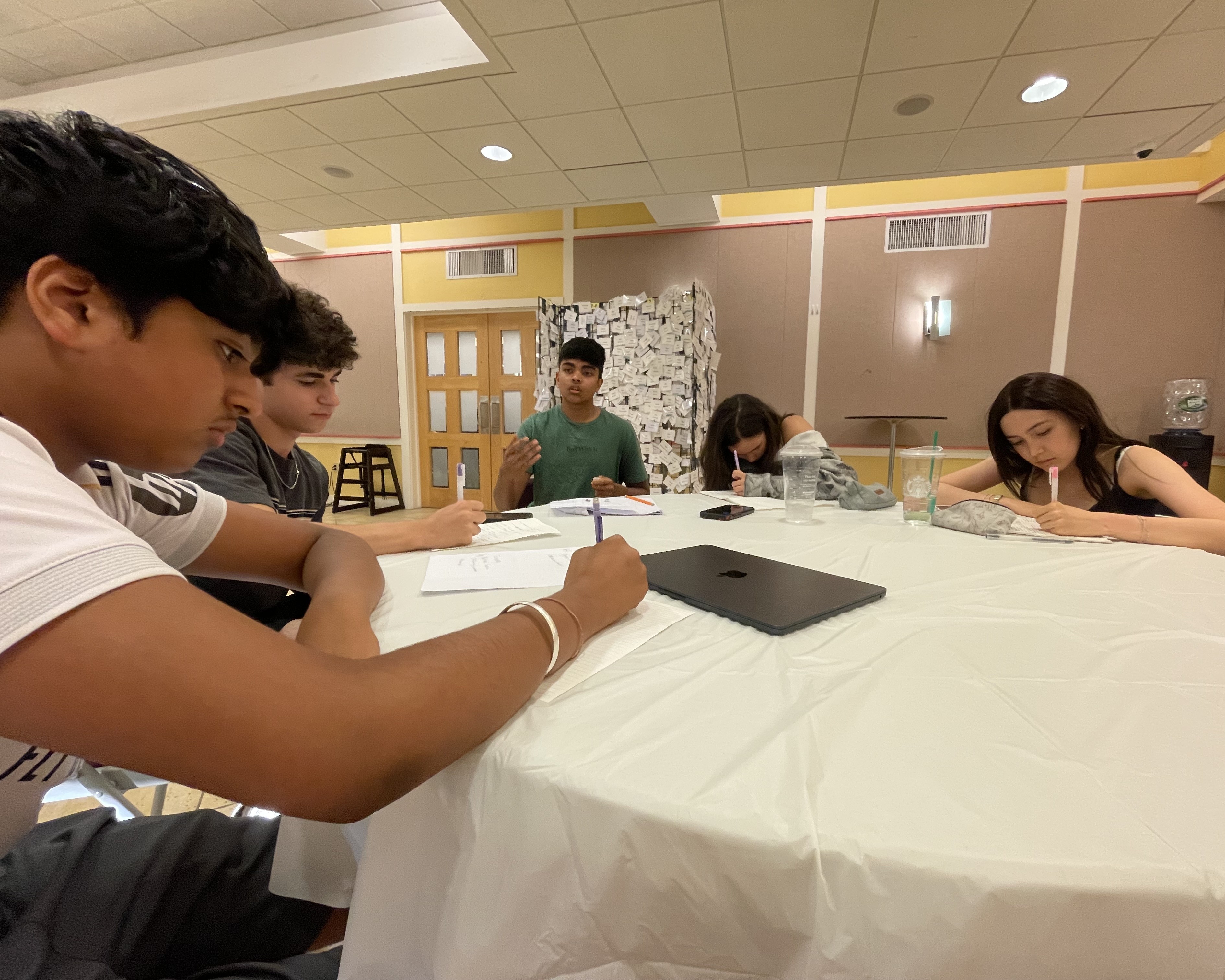 Students writing and discussing arguments during a small-group activity